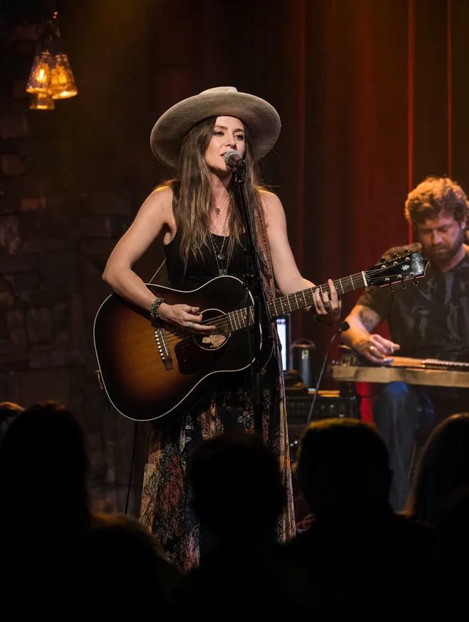 Singer performing with a guitar on a Nashville stage